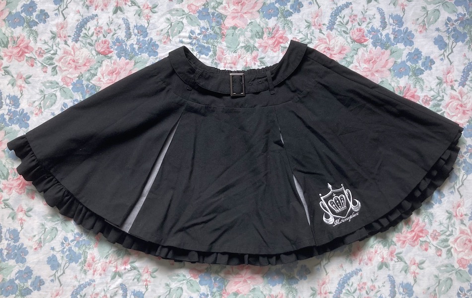 black skirt with silver emblem embroidery
